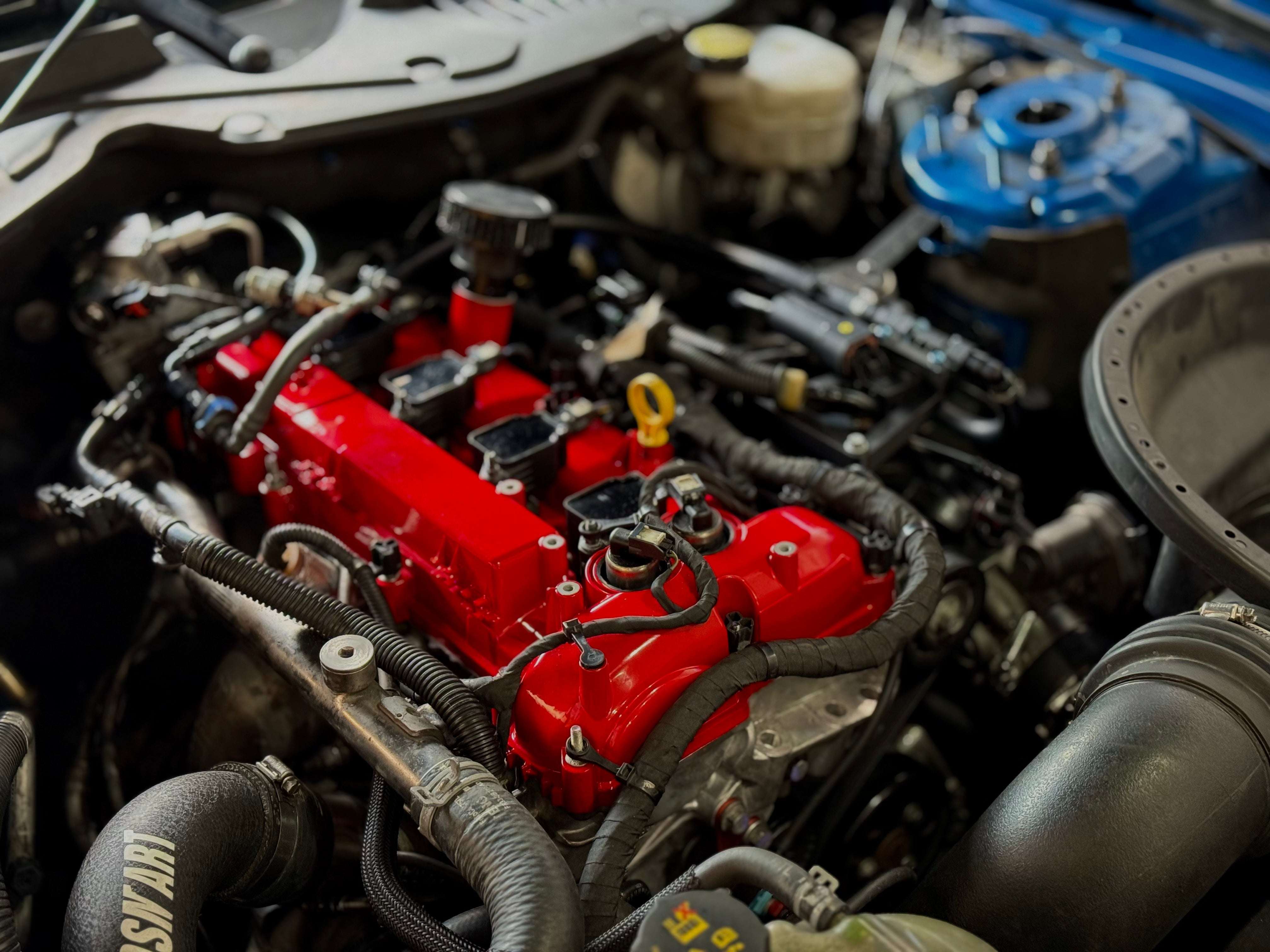 Close-up of a freshly powder-coated valve cover with high-gloss finish and metallic details