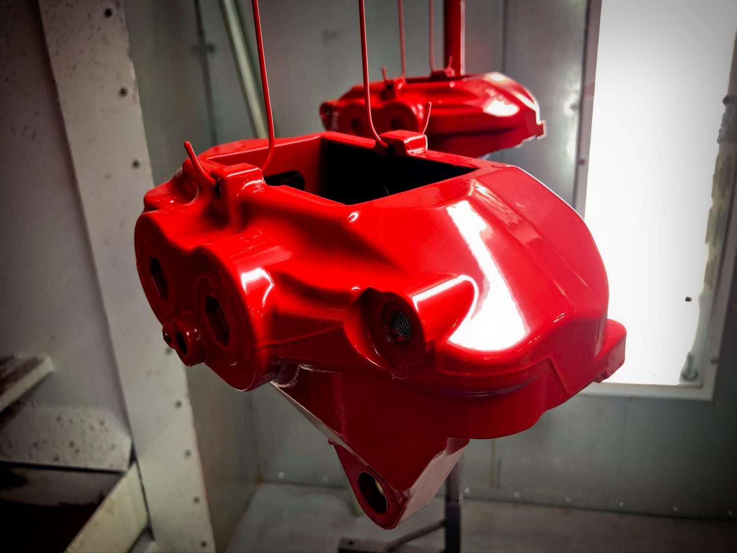 Close-up of a high-performance brake caliper with custom brake caliper powder coating in metallic red finish